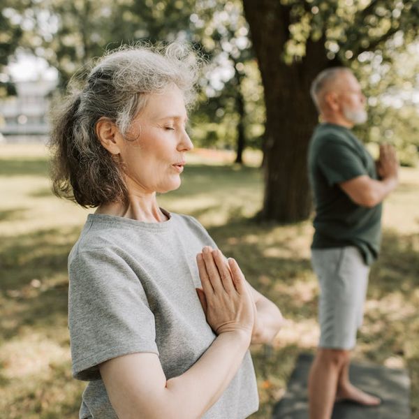 Person meditating peacefully in a serene natural environment.